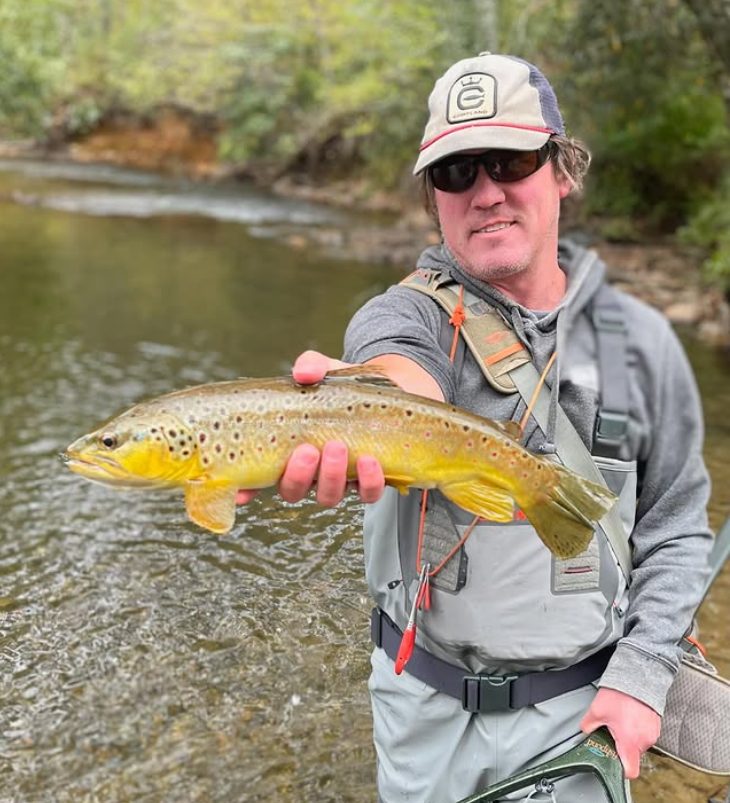 Hunter Morris holding a wild brown trout streamside